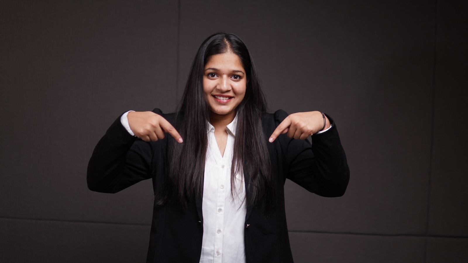 Surbhi Rawat pointing down toward the contact form